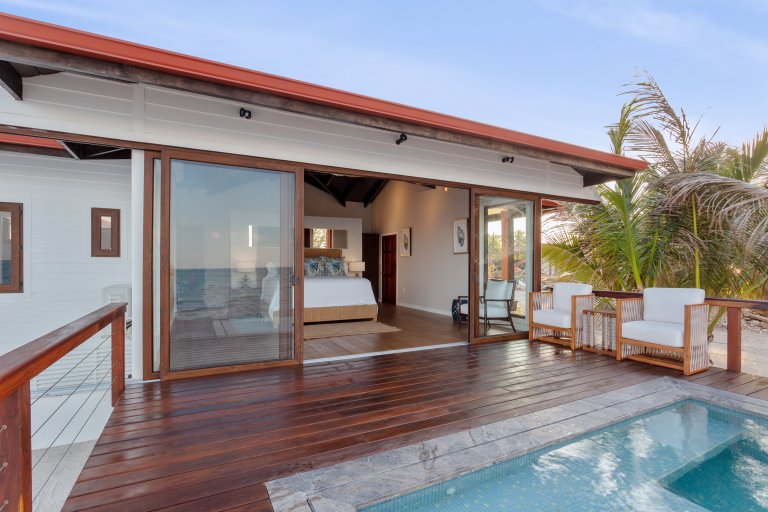 a bedroom view of ray caye resort suite with private pool