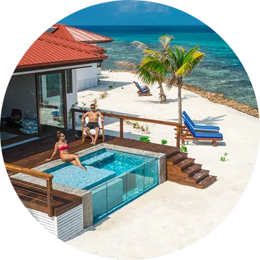 Couple relaxing by a private pool overlooking the Caribbean Sea at Ray Caye Island Resort, Belize.